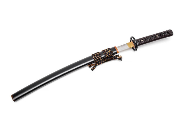 Corbata de cuero marrón en empuñadura Ajuste de acero espada japonesa y vaina negra sobre fondo blanco
. - Foto, Imagen