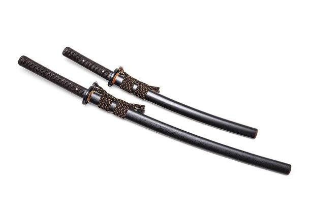 Cravatta in pelle marrone su impugnatura spada giapponese e fodero nero con raccordo in acciaio isolato su sfondo bianco
. - Foto, immagini