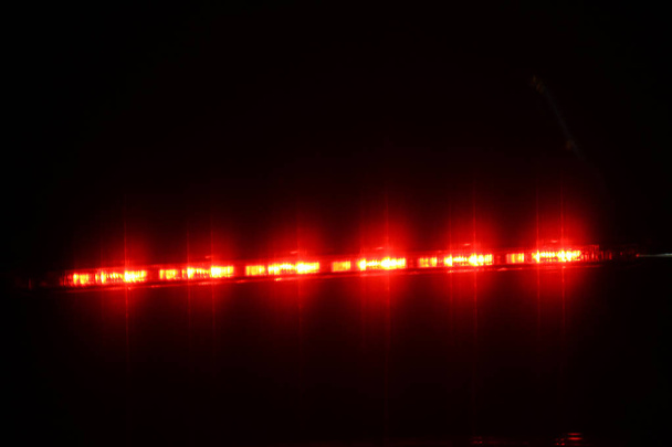 waarschuwing lichte auto, remlicht, alarmknipperlichten nacht lichteffect achtergrond zachte wazig op zwart voor flash kleurrijke ontwerpen tempo gloed - Foto, afbeelding