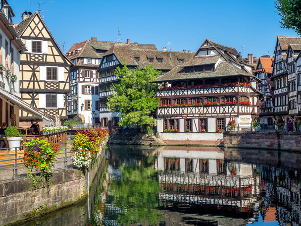 Prachtig uitzicht langs de rivier Ill in Petite France gebieden van Straatsburg in de Elzas van Frankrijk. De huizen zijn de traditionele halve houten huisjes zichtbaar. - Foto, afbeelding