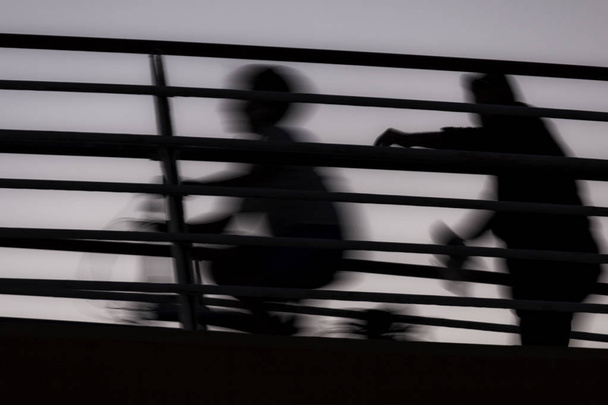 Varjot mies kävelee takana mies ratsastus polkupyörällä - abstrakti
 - Valokuva, kuva