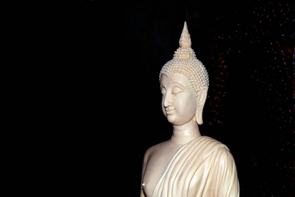 Fehér Buddha szobor, a fekete háttér, a Buddha készült elefántcsont faragott fehér, elefántcsont faragott - Fotó, kép