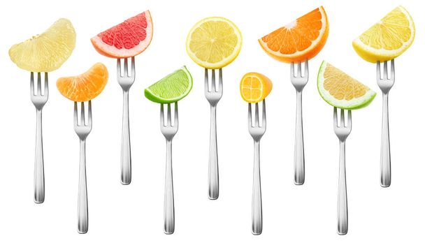 Collection isolée de morceaux d'agrumes. Fruits de pamplemousse, citron, orange, citron vert et kumquat sur une fourchette à dessert isolée sur fond blanc avec chemin de coupe
 - Photo, image