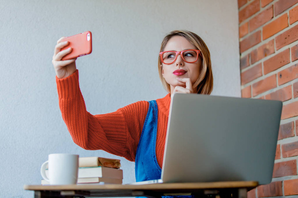 sititng dívka u stolu s počítačem a udělat selfie - Fotografie, Obrázek