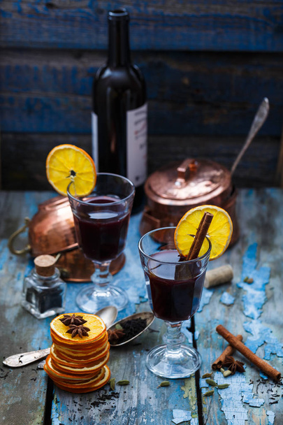 Muokattu viini appelsiiniviipaleilla ja mausteilla varustetuissa laseissa
 - Valokuva, kuva
