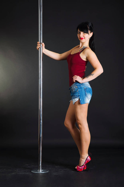 Beautiful brunette dancing on a pole - Fotó, kép