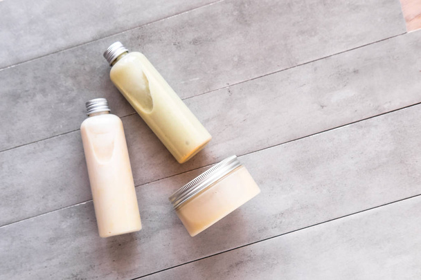 Bottiglie con prodotti cosmetici termali dall'alto su tavolo di cemento grigio. Beauty blogger, concetto di trattamenti da salone. Minimalismo - Foto, immagini