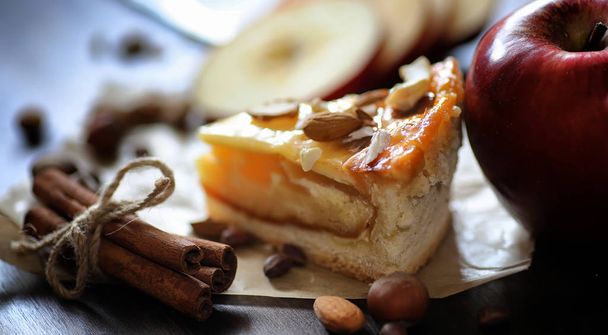 Pie with cinnamon and apples on a wooden table. Fresh pastry wit - Фото, изображение