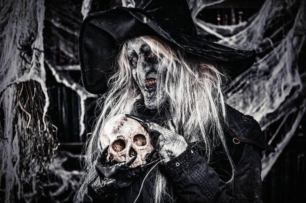 Una bruja sosteniendo un cráneo. Halloween. Película de terror
. - Foto, imagen