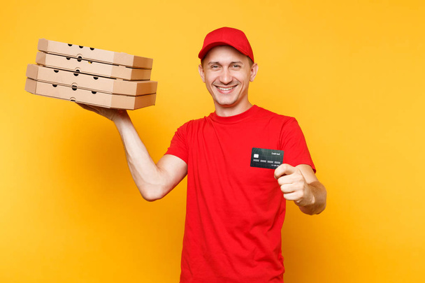 Człowiek dostawy w Czerwonym Kapturku t-shirt żywności zamówienia pizza pola na białym tle na żółtym tle. Kurier ' Pizzaman ' mężczyzna pracownik gospodarstwa włoska pizza w tekturowe flatbox karty kredytowej. Pojęcie usługi - Zdjęcie, obraz
