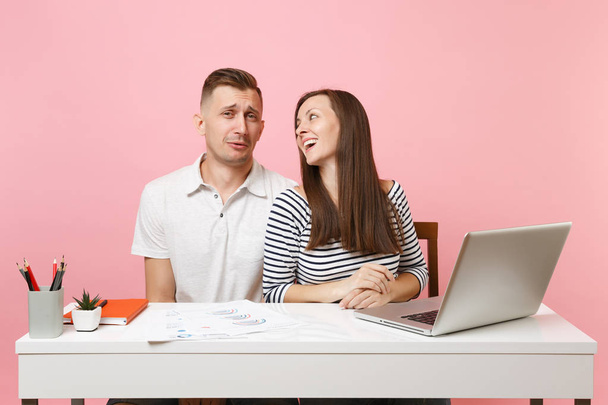 Two young tender business woman man colleagues sit work at white desk with contemporary laptop isolated on pastel pink background. Achievement career concept. Copy space advertising, youth co working - Photo, Image