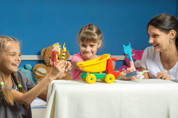 Mom plays with two daughters in a self-made finger puppet theater - Photo, Image