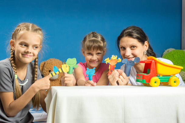 Mom with two daughters playing in a makeshift finger puppet theater - Photo, Image