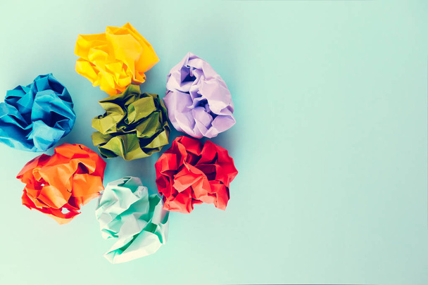 Colorful crumpled paper balls on pastel blue colored background.  Copy space, top view - Photo, Image