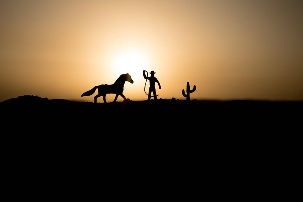 Kovboy kavramı. Günbatımı zaman siluet kovboy. Kovboylar siluetleri atları ile bir tepede. Seçici odak - Fotoğraf, Görsel