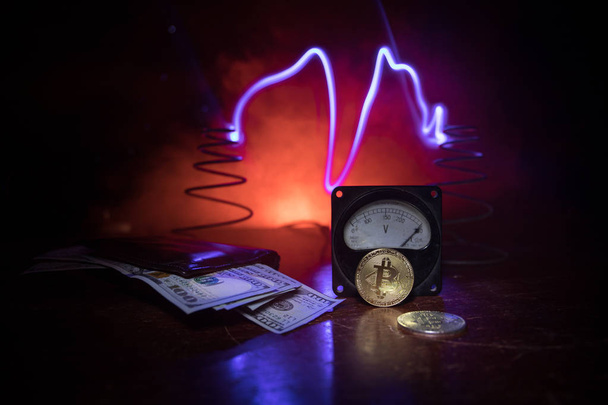 Energy for mining cryptocurrency. The energy meter with bitcoin and money on dark toned foggy background. Power Counter Meter Voltage Measuring Outlet Power consumption of Mining Rig. Selective focus - Φωτογραφία, εικόνα