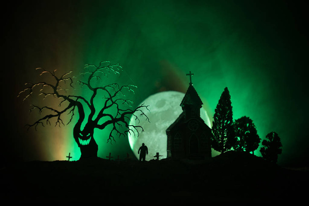 Τρομακτικό άποψη των ζόμπι στο νεκροταφείο νεκρό δέντρο, φεγγάρι, εκκλησία και spooky συννεφιασμένο ουρανό με ομίχλη, φρίκης αποκριών έννοια. Ήπια - Φωτογραφία, εικόνα