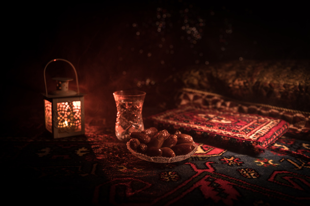 Água e datas. O alcatrão é a refeição da noite. Vista da decoração Ramadan Kareem férias no tapete. Cartão festivo, convite para o mês sagrado muçulmano Ramadã Kareem. Foco seletivo
 - Foto, Imagem