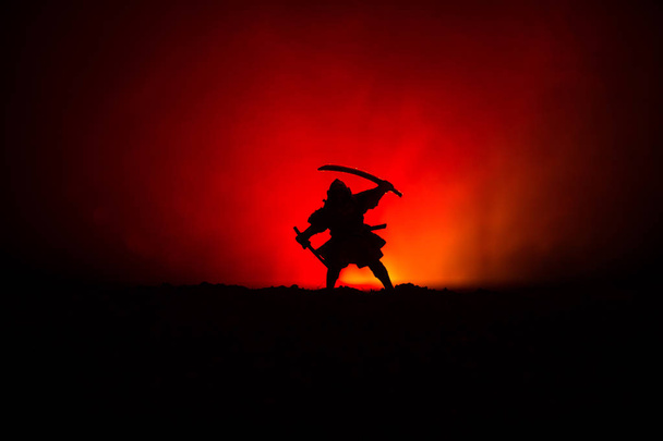 Vechter met een zwaard silhouet een hemel ninja. Samurai bovenop de berg met donker getinte mistige achtergrond. Selectieve aandacht - Foto, afbeelding