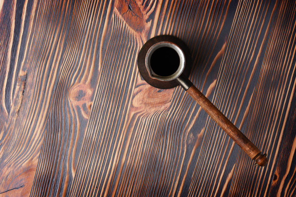 Вид сверху на медно-турецкий кофейный пот на деревянном фоне
 - Фото, изображение