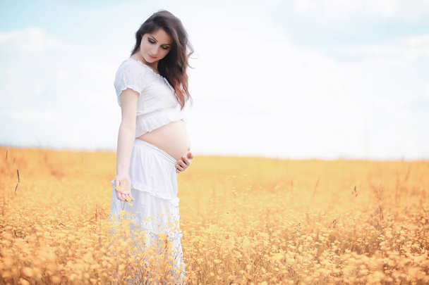 Pregnant woman in nature for a walk in the autumn - Photo, Image