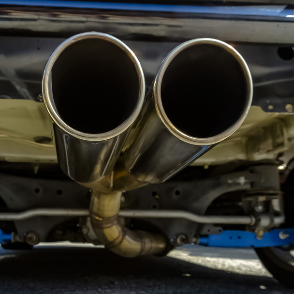 Закрытие двойной выхлопной трубы в задней части автомобиля
 - Фото, изображение