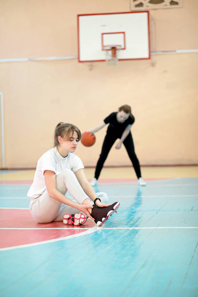 Fiatal diák lány a tornaterem, kosárlabda játék - Fotó, kép