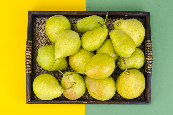 Tray with ripe juicy delicious pears on bright background - Fotoğraf, Görsel