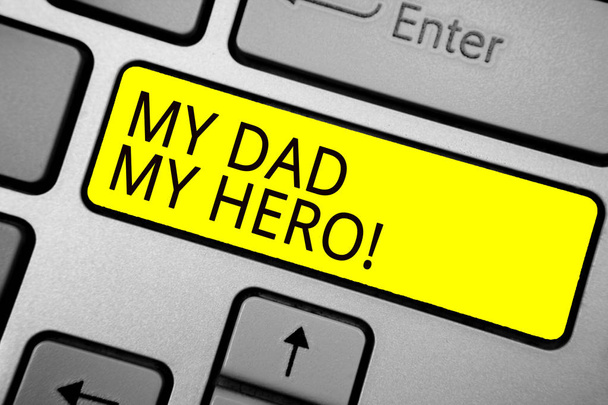 Χειρόγραφο κείμενο γράφοντας μου ο μπαμπάς μου ήρωα. Έννοια έννοια θαυμασμό για τον πατέρα αγάπη συναισθήματα συναισθήματα φιλοφρόνηση Τεφρώδες πληκτρολόγιο του υπολογιστή σας με το κίτρινο κουμπί μαύρο χρώμα κειμένων. - Φωτογραφία, εικόνα
