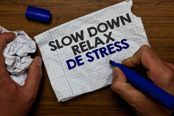 Word pisanie tekstu Slow Down Relax De stres. Biznes koncepcja sobie zrobić przerwę, zmniejszyć stres poziomy reszta spokojny ręka trzymać papier lob i niebieski znacznik drewniana podstawa z strona poszarpane napisał biały. - Zdjęcie, obraz