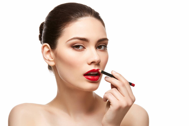 toepassing van rode lippenstift geïsoleerd op wit meisje - Foto, afbeelding