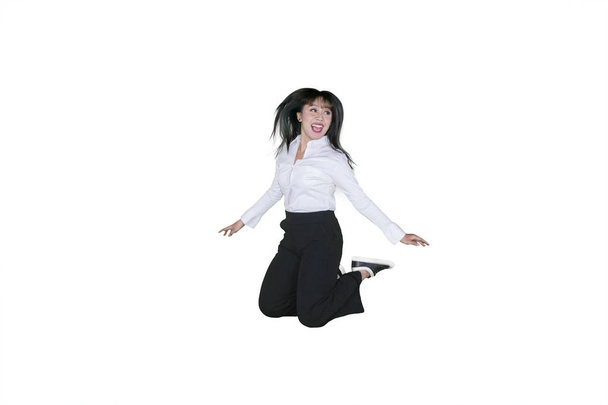 Picture of young businesswoman celebrating success by jumping in the studio, isolated on white background - Fotó, kép