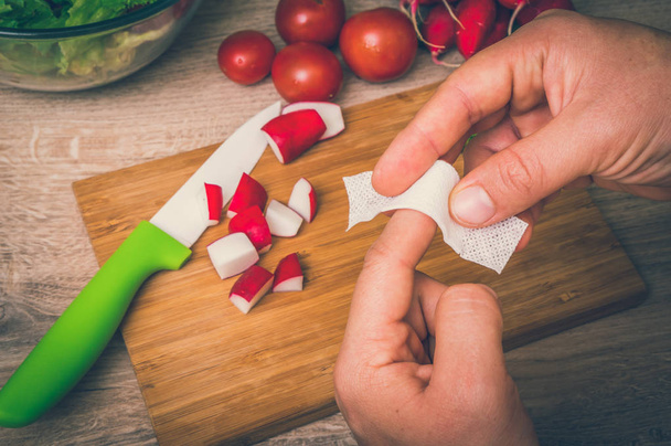 Женщина наносит пластырь на палец - травма на кухне - ретро стиль
 - Фото, изображение