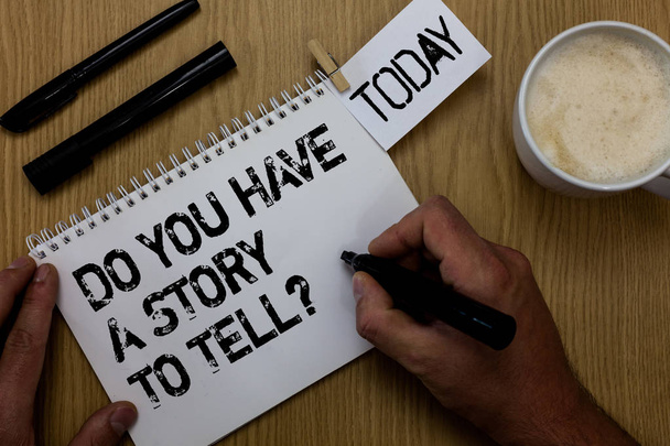 Text sign showing Do You Have A Story To Tell question. Conceptual photo Storytelling Memories Tales Experiences Paperclip retain written notepad hand hold marker coffee black pen on woody desk. - Photo, Image