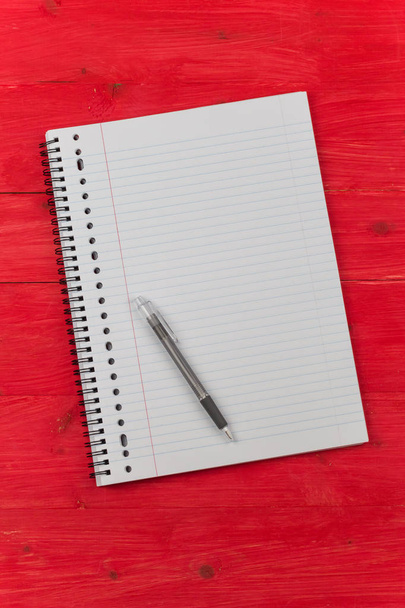 Not defteri ve kalem kırmızı ahşap bir masa üzerinde - Fotoğraf, Görsel