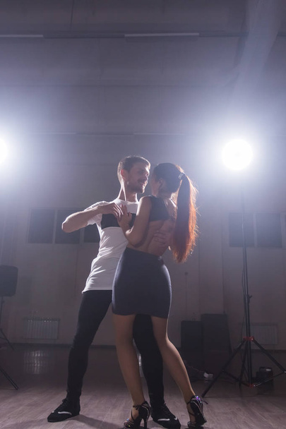 Young couple dancing latin dance Bachata, merengue, salsa. Two elegance pose in dance class - Photo, image