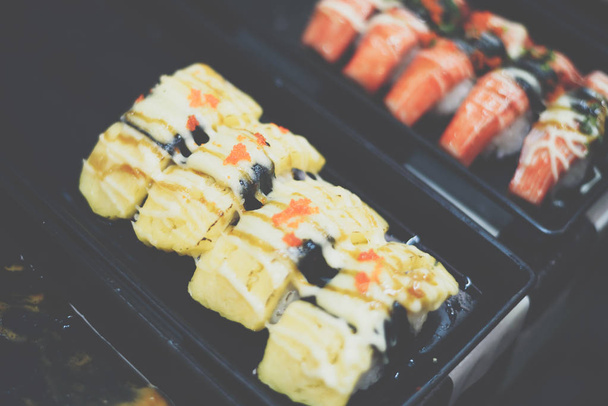 La comida japonesa en diferentes tipos de sushi con ensalada de algas marinas y gari (jengibre) es un alimento saludable en la parte superior derecha de la tabla de servir en el restaurante japonés.
 - Foto, imagen