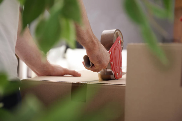 Man packing carton box indoors, closeup. Moving day - Foto, immagini
