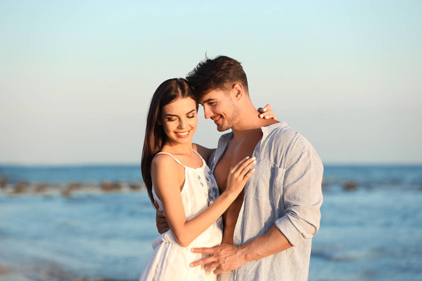 Happy young couple posing near sea on beach - Foto, immagini
