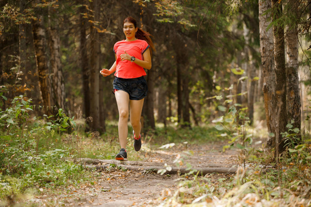 Photo of sports girl running through park - Photo, Image