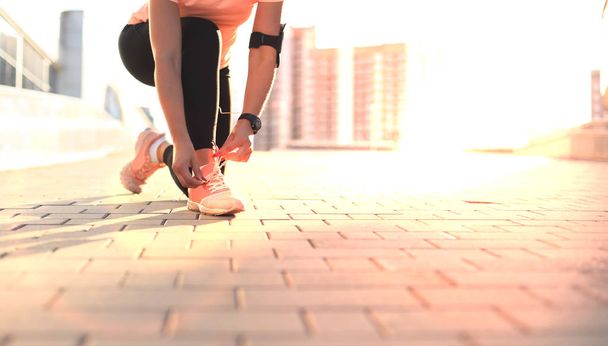Jeune fille sportive attrayante fitness coureur attache les lacets sur ses chaussures de sport se préparer à courir
. - Photo, image