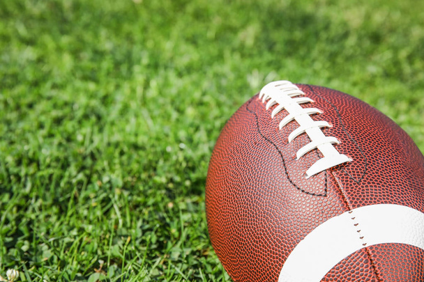 Pallo amerikkalaisen jalkapallon tuoreen vihreän kentän ruoho, lähikuva. Tekstitila
 - Valokuva, kuva