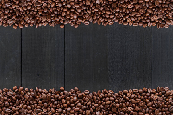 grano de café sobre fondo de madera negra. vista superior
 - Foto, imagen