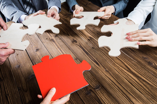 Group of business people assembling jigsaw puzzle and represent team support and help concept - Photo, Image