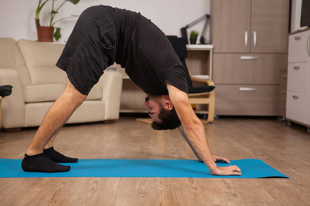 Adult man doing Dolphin yoga pose in his workout routine - Foto, Imagem