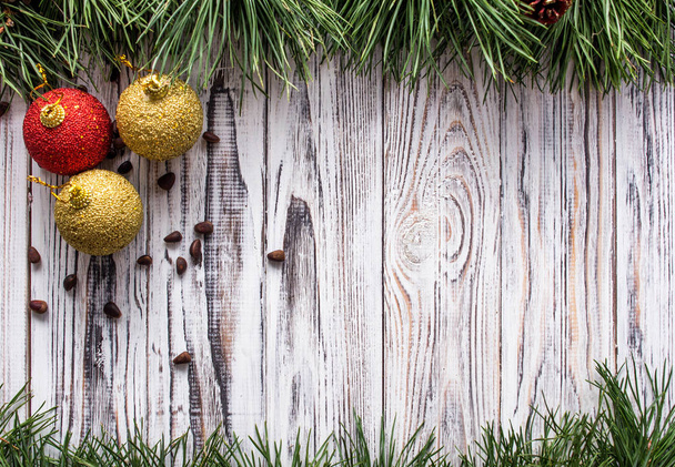 three New Year's ball toys with pine nuts on a white wooden background, sosonic branches, copy space - Valokuva, kuva