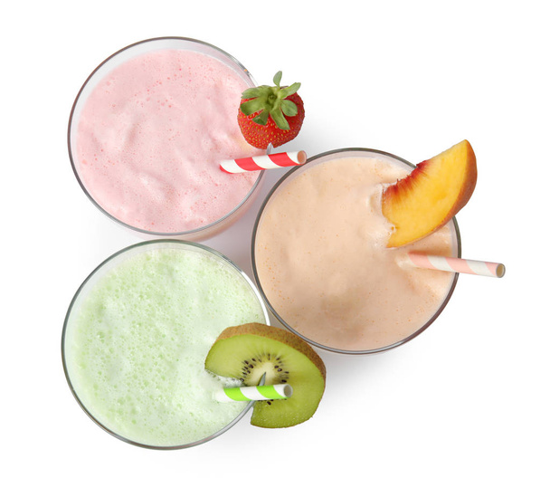 Glazen smakelijke milkshakes op witte achtergrond, bovenaanzicht - Foto, afbeelding