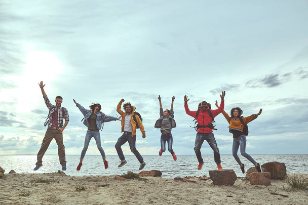 Group of friends jumping on the beach - Фото, зображення