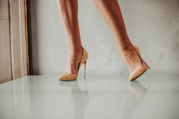 Woman feet wearing high heel beige shoes - Fotografie, Obrázek