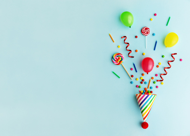 Chapéu de festa com doces, balões e velas de aniversário
 - Foto, Imagem